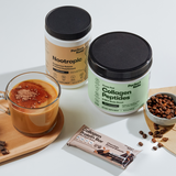 Supplement jars, a protein bar, and a cup of coffee on a white surface