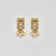 Gold earrings with pearl drops on a light gray background
