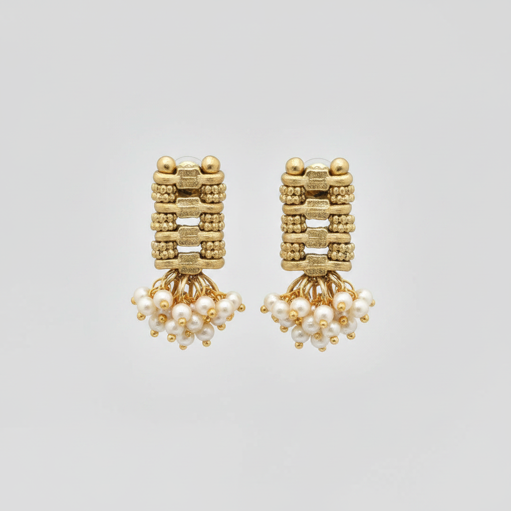 Gold earrings with pearl drops on a light gray background