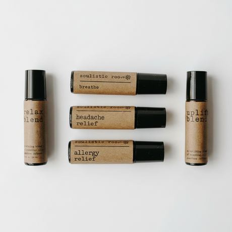 Set of five essential oil roller bottles with labels on a white background