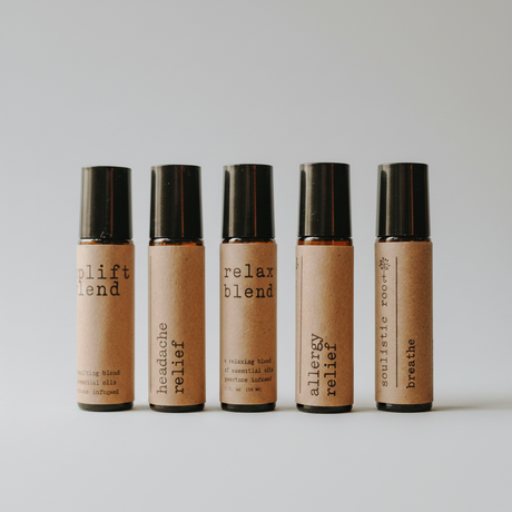 Five roller bottles with different labels on a white background