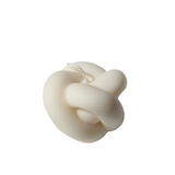 White knot-shaped candle on a white background