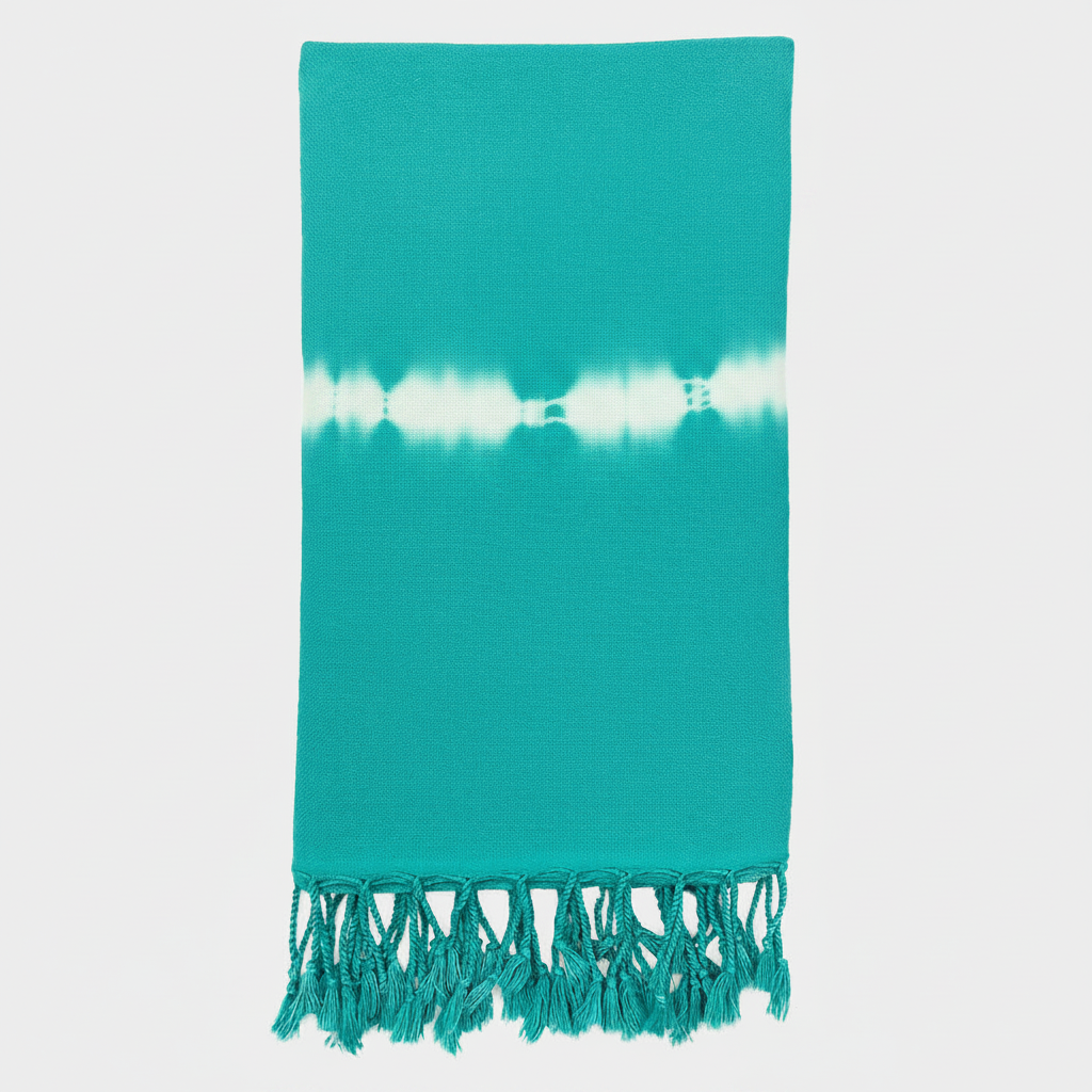 Teal towel with white tie-dye pattern and fringes on a light gray background