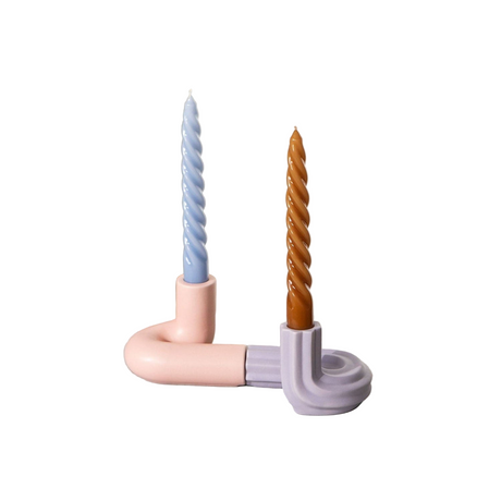 Two candle holders with pastel-colored pipes holding candles on a white background