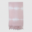Pink and white tie-dye towel with fringes on a light gray background