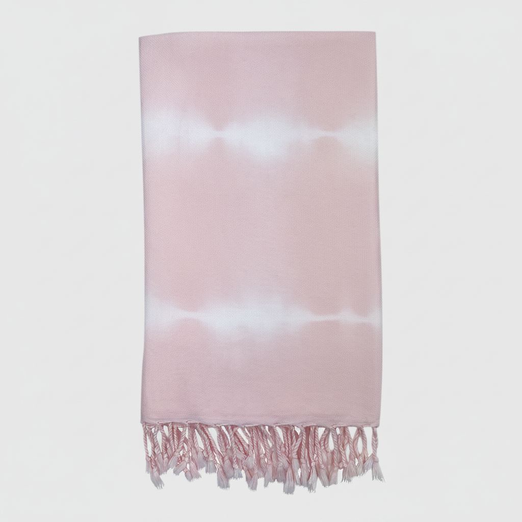 Pink and white tie-dye towel with fringes on a light gray background