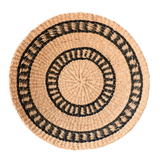 Woven placemat with black patterns on a white background