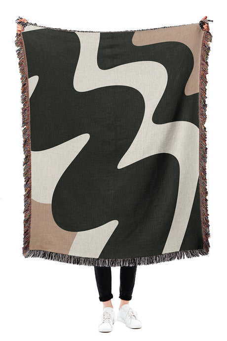 Black and white woven throw blanket with an abstract zig-zag pattern and modern design.
